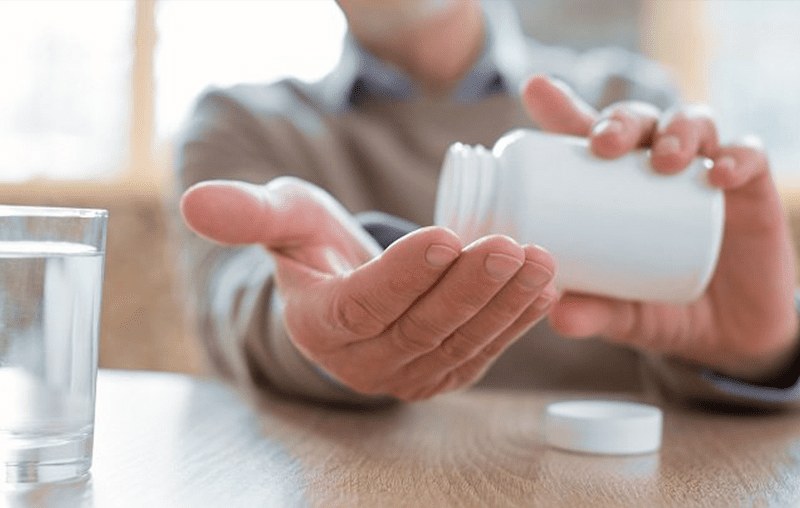 A person holding onto a bottle of medicine